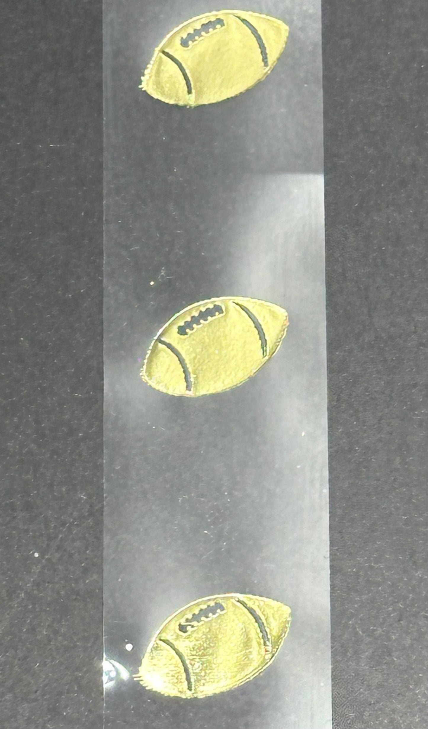 Narrow Gold football on clear ribbon
